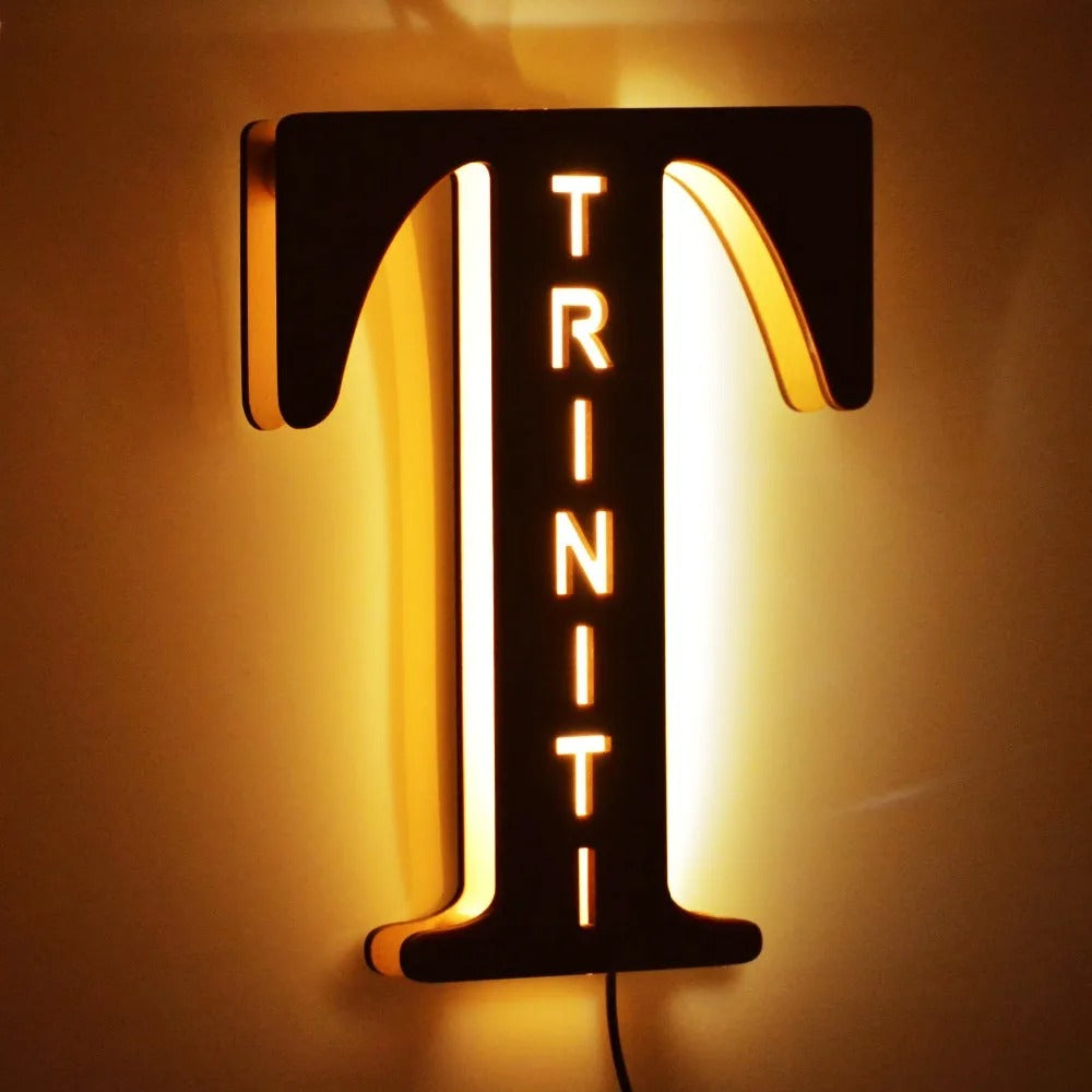 Engraved wooden name sign lamp, lit, large letter T with example word cut out and glowing