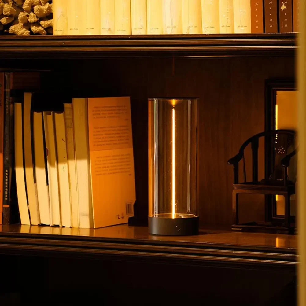 Minimalist Column Table Lamp lit on a bookshelf