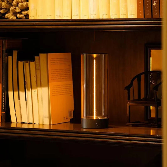 Minimalist Column Table Lamp lit on a bookshelf
